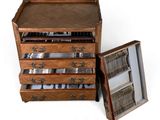 a wooden chest of drawers with silverware in it