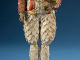 an old fashioned figurine of a man wearing a red jacket and white pants