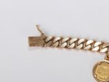 a gold chain bracelet with a gold coin on it