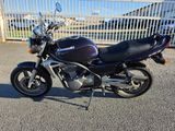 a black motorcycle parked in front of a white fence