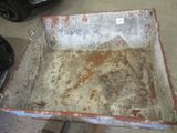 une caisse métallique rouillée posée sur une palette en bois