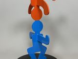 a blue and orange sculpture of a man holding a t