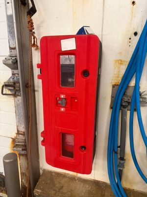 une machine rouge qui se trouve à côté d'un tuyau bleu