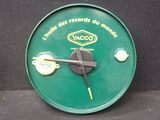 une horloge verte avec un cadran noir posée sur une surface noire