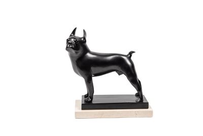 une statue noire représentant un chien debout sur un socle en bois
