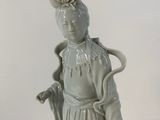 a figurine of a woman holding a basket of flowers