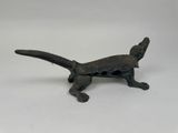 an old bronze figurine of a cat on a white surface