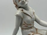 a statue of a woman sitting on top of a box