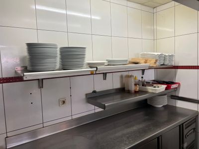 une cuisine avec beaucoup de vaisselle sur le comptoir
