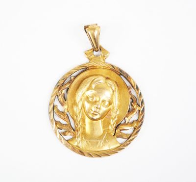 a close up of a gold pendant with a woman ' s face on it
