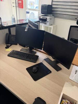 un bureau sur lequel sont posés deux écrans d'ordinateur et un clavier