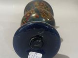 a blue vase with a picture on it sitting on a table
