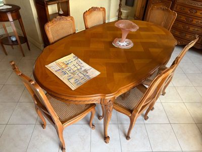 a table with chairs and a vase on top of it