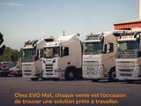 four trucks parked in a parking lot with a building in the background
