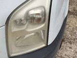 a close up of a car ' s headlight on a dirt road