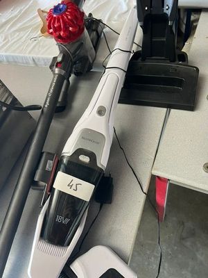 un aspirateur posé sur une table à côté d'un ordinateur portable