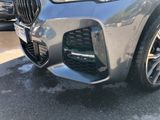 the front of a silver bmw suv parked in a parking lot