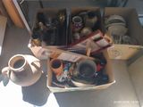 une boîte remplie de tasses à café et d'autres objets, posée par terre
