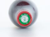 a close up of a bottle of wine on a white surface