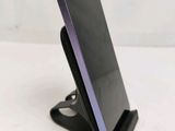 a close up of a cell phone on a stand on a white surface