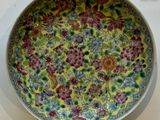 a yellow and red plate with flowers on it