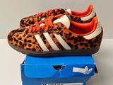 baskets Adidas à imprimé léopard avec des lacets orange, posées sur une boîte bleue