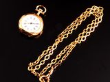 montre de poche plaquée or avec sa chaîne, sur fond noir