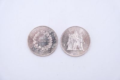 deux pièces d'argent posées l'une à côté de l'autre sur une surface blanche