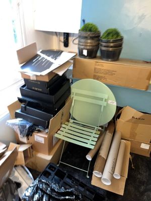 une pile de cartons et une chaise dans un coin de la pièce
