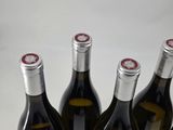 four bottles of wine are lined up in a row