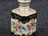 an image of a small black and white bottle with flowers on it
