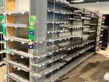 many empty shelves in a store that are full of items