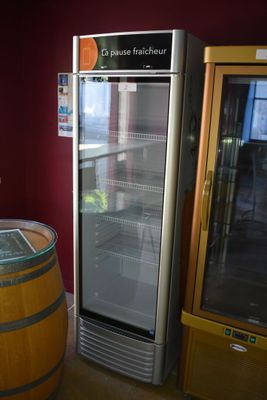 une cave à vin posée à côté d'un tonneau en bois dans une pièce