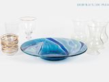 un bol bleu et blanc et des verres posés sur une table