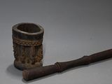 une vieille pipe avec un manche en bois posée sur une table