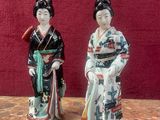deux figurines représentant des femmes asiatiques debout l'une à côté de l'autre