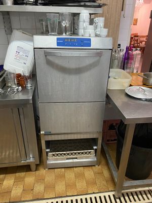 a dishwasher in the middle of a kitchen with a lot of dishes on the counter