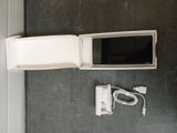 a white microwave sitting on a counter next to a charger