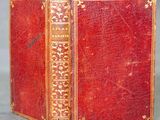 un vieux livre rouge avec des bordures dorées et des bordures dorées