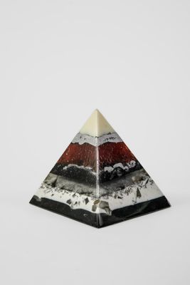 un gros plan d'un objet en forme de pyramide posé sur une surface blanche