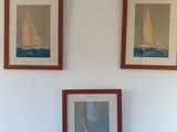 trois tableaux accrochés au mur au-dessus d'un lit