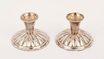 pair of silver candlesticks on a white background