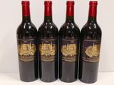 four bottles of red wine are lined up on a table