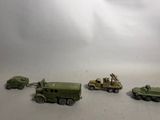several toy army vehicles are lined up on a white surface