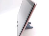 a tablet computer sitting on a stand on a white surface