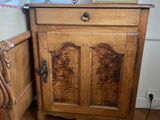 a wooden cabinet sitting next to a bed in a room