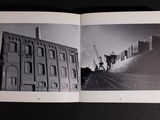 a black and white photo of a book opened to show a black and white photo of a building