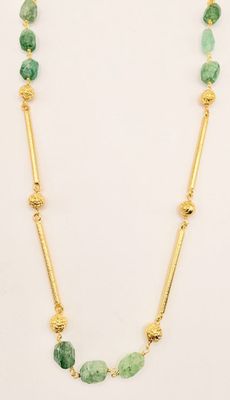 a necklace with green stones and gold beads on a white background