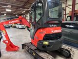 a small red excavator parked in a garage