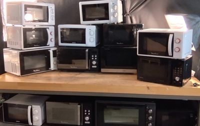 de nombreux micro-ondes posés sur une étagère dans une pièce